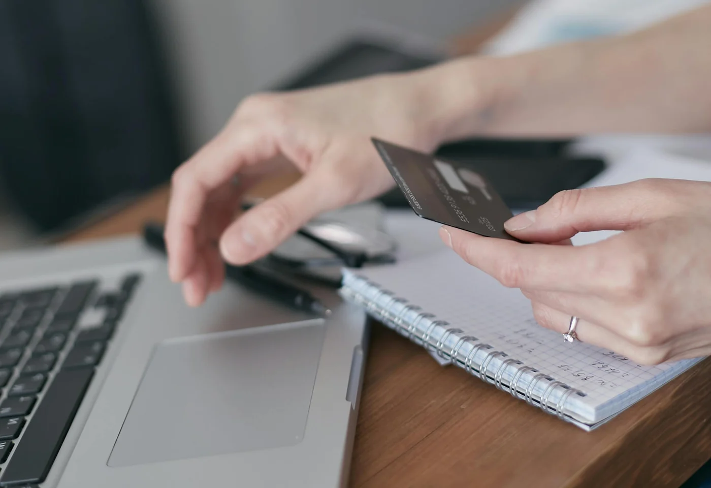 Person schließt eine Online-Zahlung mit Karte und Laptop ab.